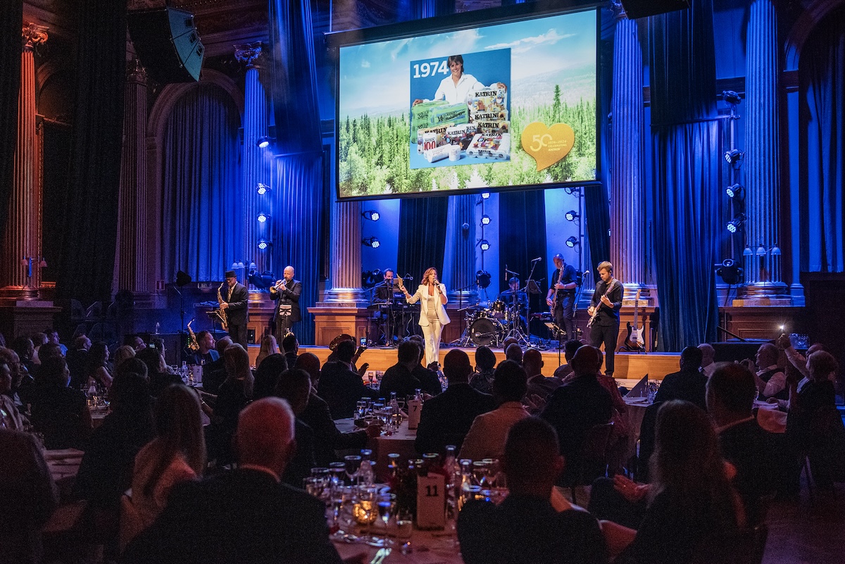 Konferensier pratar på scenen när Metsä Tissue firar att varumärket Katrin fyller 50 år. Platsen är Café Opera i Stockholm.